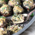 Spinach Parmesan Stuffed Mushrooms are tasty as an appetizer or side dish. A creamy, cheesy and garlicky spinach filling is packed into perfectly sized baby bella mushrooms and topped with crispy breadcrumbs and melted butter.