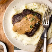 sirloin steak and mashed potatoes drizzled with bourbon peppercorn cream sauce