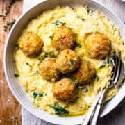 chicken meatballs over creamy spinach orzo in a bowl