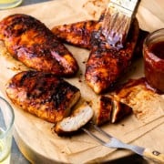 slathering smoked chicken breasts with bbq sauce