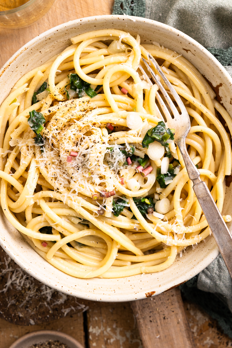 ramp pasta in a bowl topped with shredded parmesan and black pepper