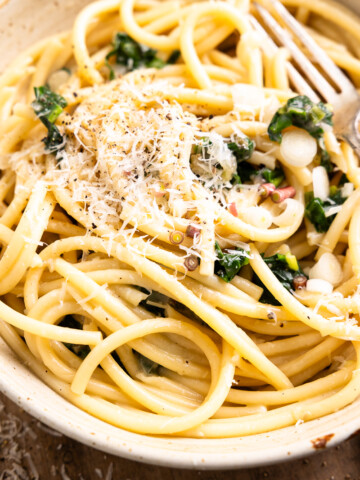 close up of ramp pasta in a bowl and garnished with parmesan and black pepper