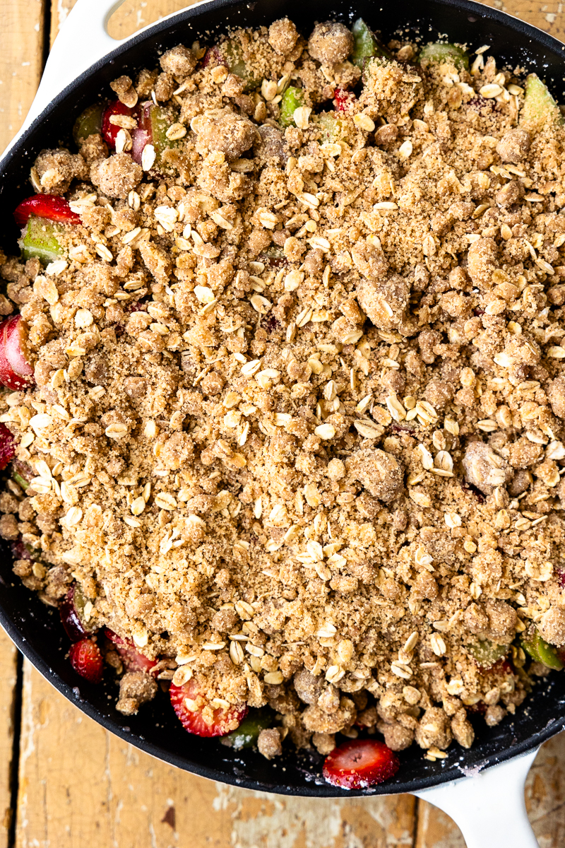 assembled strawberry rhubarb crisp in a skillet before it goes into the oven