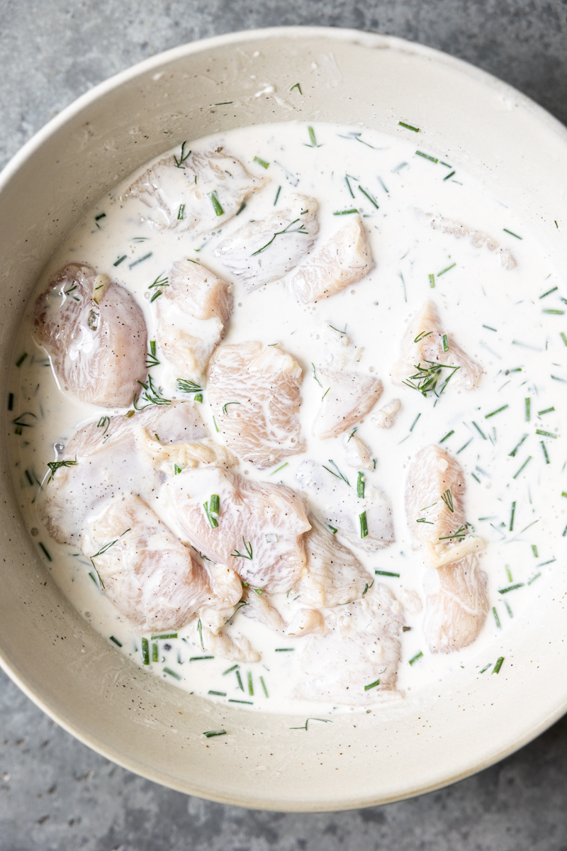 marinating small pieces of chicken in a bowl