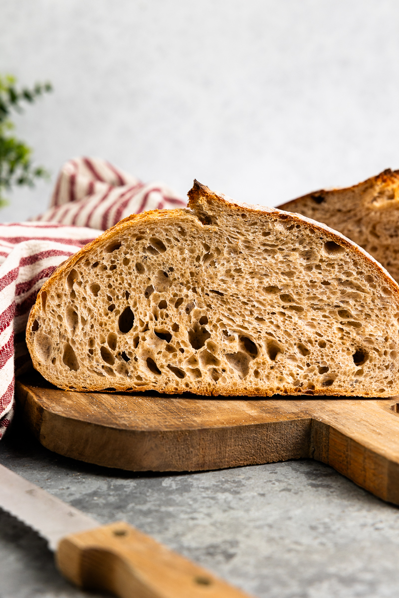 loaf of sourdough cut in half and sitting on a cutting board